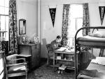 A student studies in his dorm room, undated