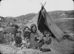 Adult and children outside tent in Austria, undated