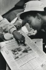 Female student looks at a newspaper during the 1989 student occupation of the Hannah Building