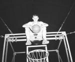 Unknown Basketball Player Sits on Hoop