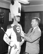 Coach Daugherty fixes a drum major's uniform, 1955
