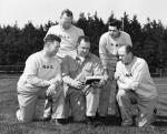 MSC football coaches read from a play book, ca. 1954
