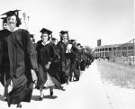 Students walk in a procession away from the Stadium, ca. 1948-1950