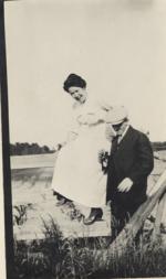 Man and woman beside fence, date unknown