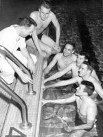 Coach Charles McCaffree speaks with swimmers, 1949