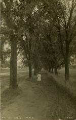 Girl walking down a path, date unknown