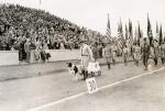 A dog marches with Boy Scouts during half-time, circa 1920s