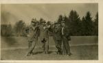 Four men standing in a field, date unknown