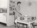 A woman sets the table in University Apartment, 1954