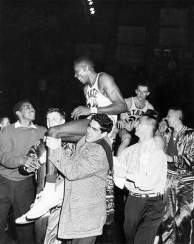 A group carries basketball players on shoulders, 1957 title=A group carries basketball players on shoulders, 1957